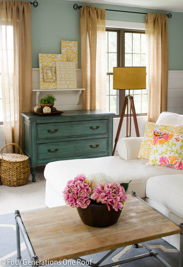 Burlap curtains DIY hung on two windows in a living room.