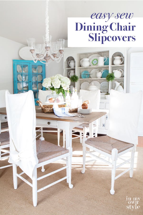 White and turquoise decorated dining room with white chairs and white DIY made slipcovers.