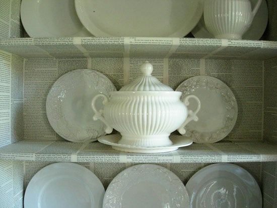 Decorating with common household items as done in this Dining room hutch that was decorated with pages from old books.