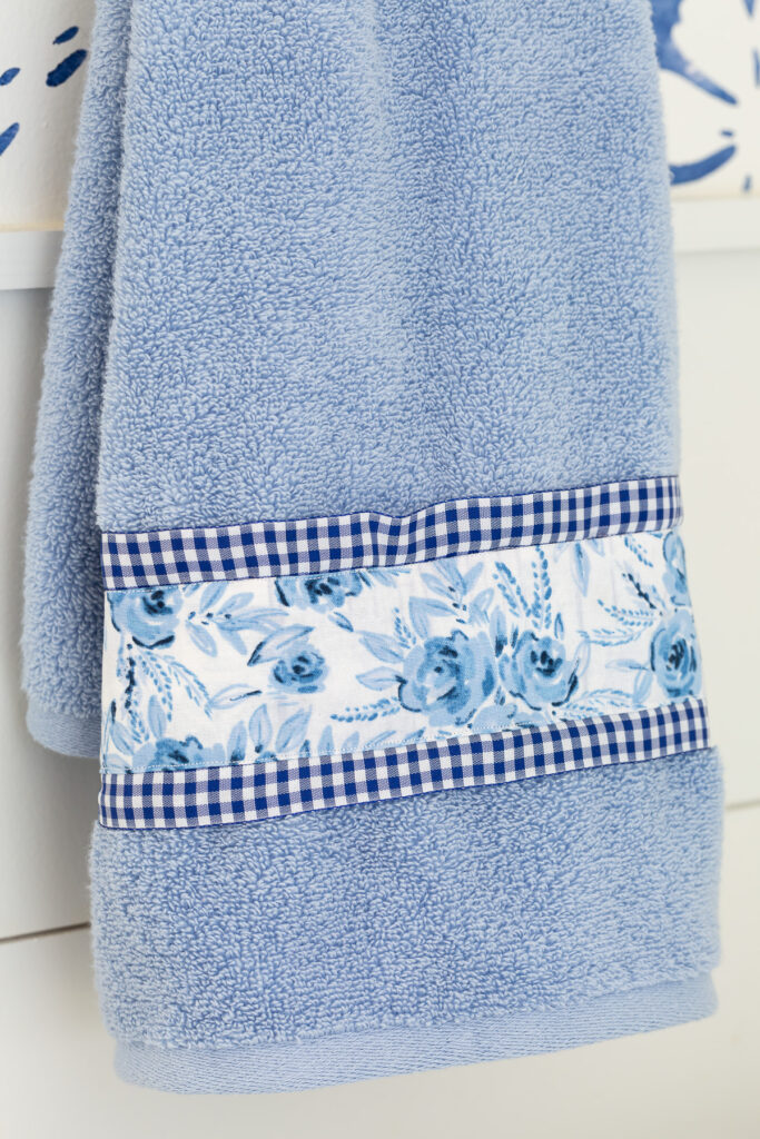 close up of a blue towel with ribbon and fabric added to it to make it more interesting and to coordinate with the decor.