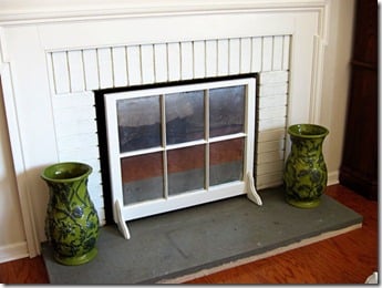 Window sash made into a fireplace firebox cover. To hide the inside of the dirty firebox area.