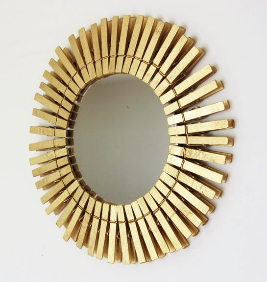 Gold Painted clothespins on a mirror to create a creative frame for a mirror