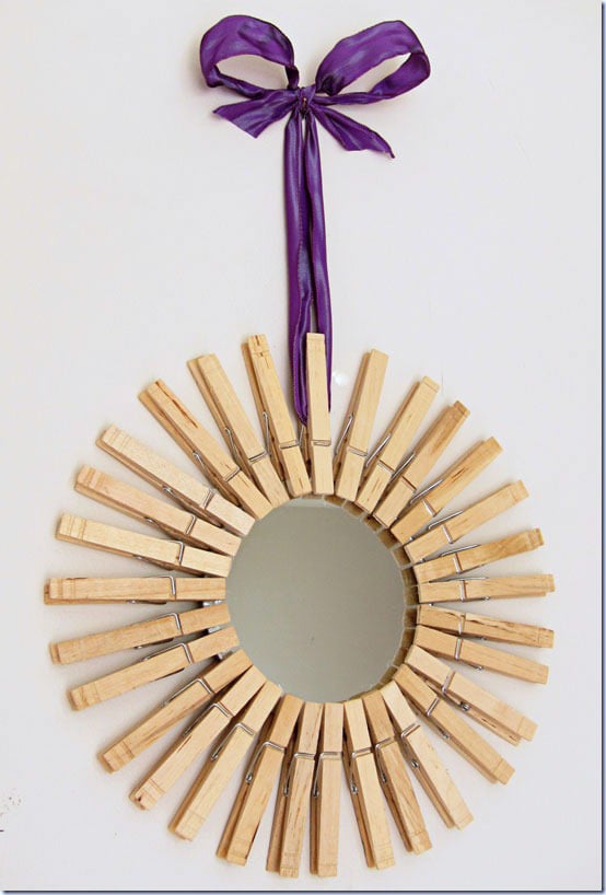 DIY Starburst mirror hung on wall with purple ribbon
