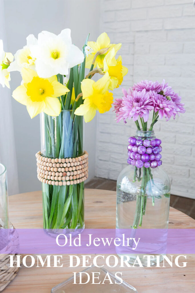2 glass vases decorated with old jewelry.