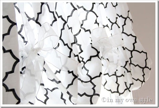 Black and white patterned No sew balloon style window valance made with a fitted sheet tied on rod with sheer white ribbon.