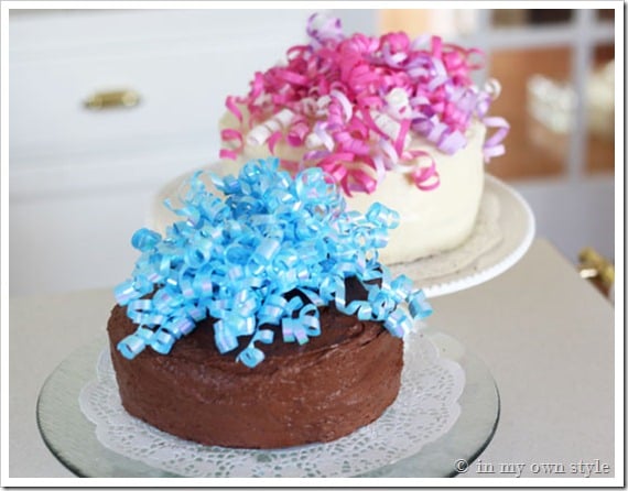 Two cakes on plate stands decorated using curling ribbons instead of fancy time consuming icing embellishments.