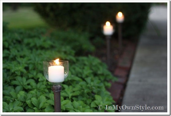 A home's front walkway lined with DIY lighting made using soda bottles. 