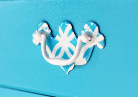Paper Napkin and epoxy makeover of a traditional brass drawer pulls to one of pattern and color. 