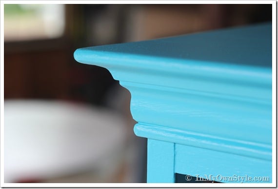 Turquoise paint on corner top of chest of drawers.