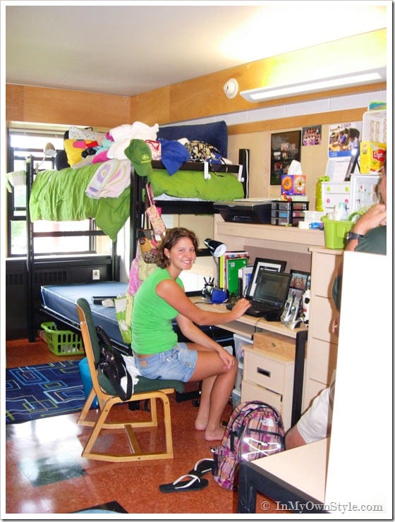 Dorm Decorating Ideas. Student sitting at desk in messy dorm room
