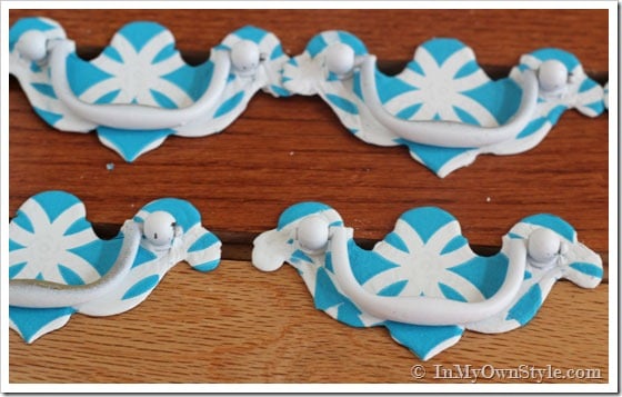 napkin-covered-drawer pull makeover showing finished pulls with turquoise and white printed napkins.