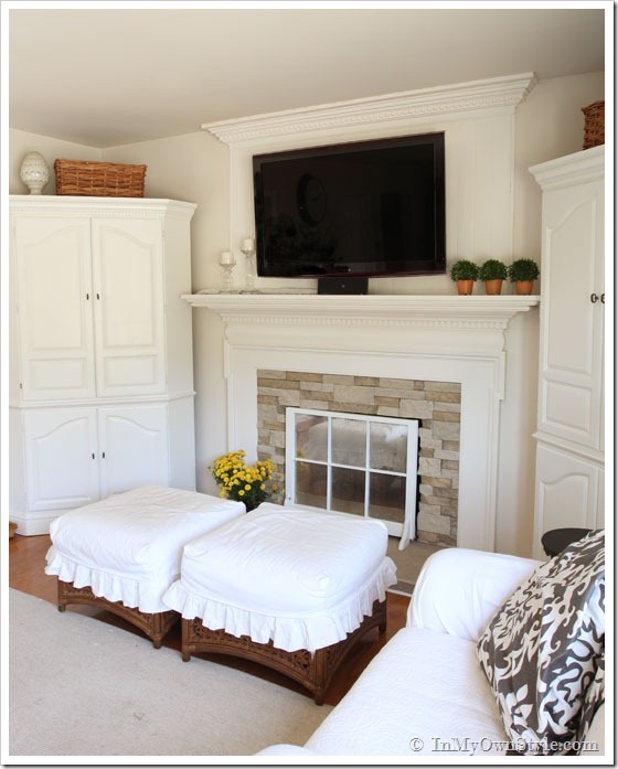 Flat screen TV mounted on wall above a fireplace. 