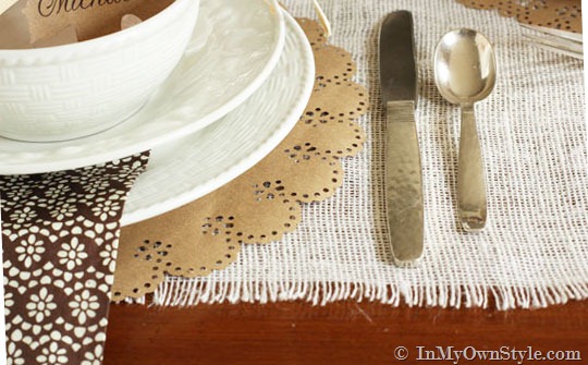 close up of white plates on a Thanksgiving table setting.