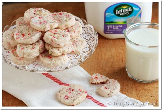 Pecan-Cherry-Cookies on a cake plate along side a big glass of cold milk.