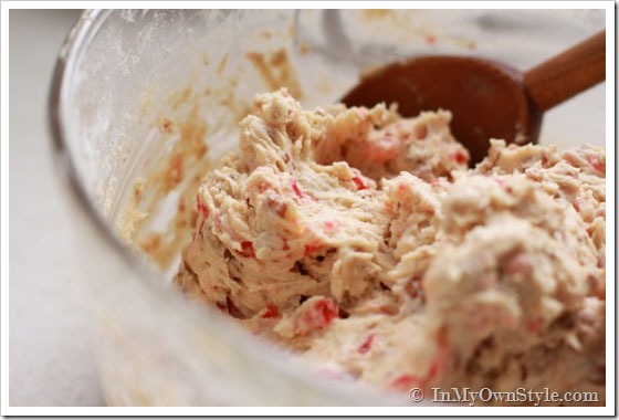 Pecan Cherry Cookie batter being spooned out of bowl.