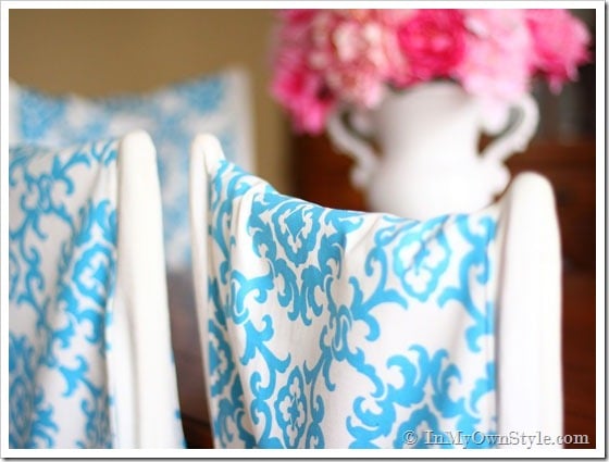 DIY chair back covers in turquoise and white on dining chairs in dining room