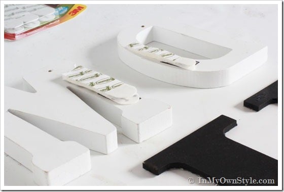 How to hang wood initials and layer them inside a gallery wall arrangement.