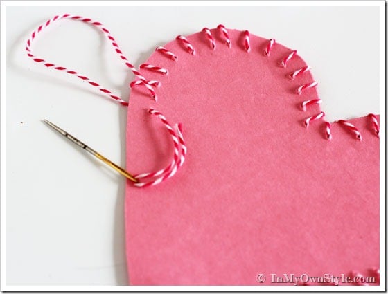 Valentine's-Day-Pink paper heart sewn with red and white Baker's Twine.