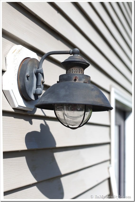 Outdoor light on side of house getting cleaned before painting.