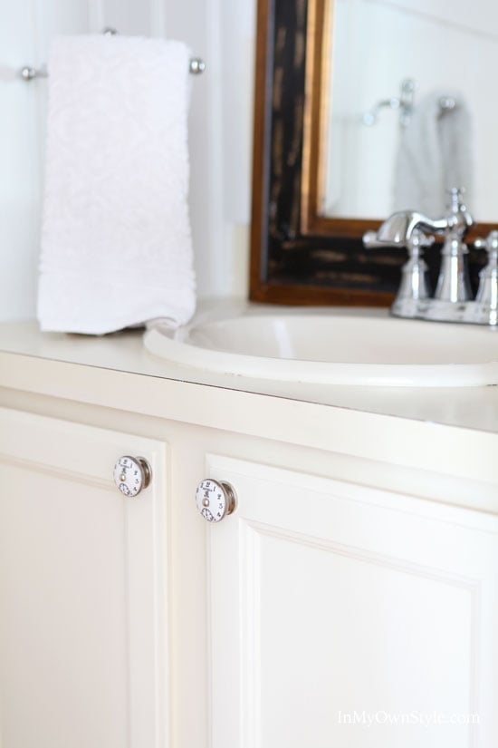 Bathroom vanity made over using off white chalk paint and clock face cabinet door knobs
