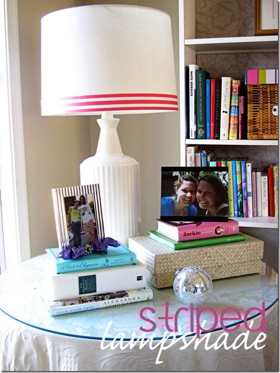 Lamp-on table. Lamp shade-has striped pink and white ribbon along bottom edge as added as decoration.