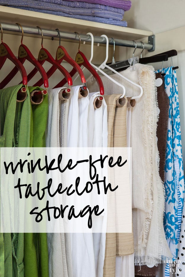 Table cloths hanging in a closet on hangers with cardboard tubes over them. Text overlay says, Wrinkle Free Tablecloth Storage.
