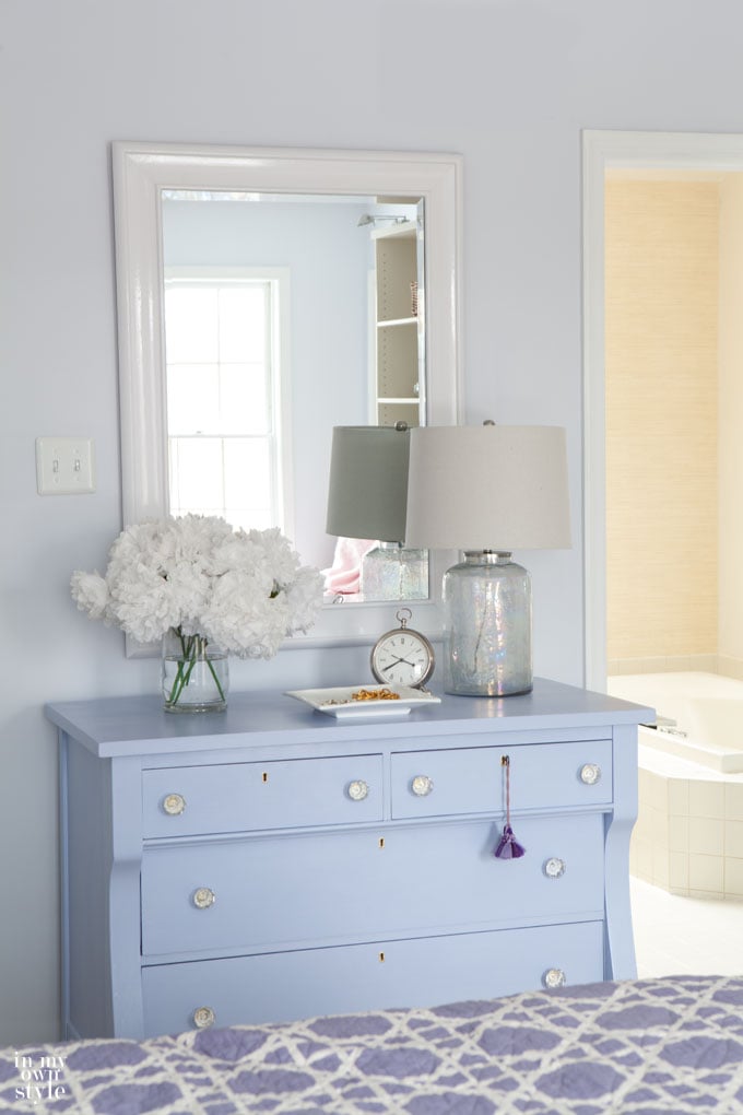 glossy white paint on mirror above blue dresser in bedroom that helps to brighten a dark room