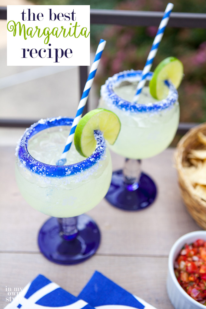 This is the Margarita recipe you have been searching for. It is the best! 2 margarita glasses on a table with limes and green and white striped straws.