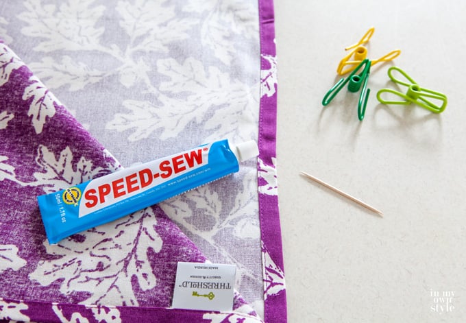purple leaf fabric getting made into a pillow using a no sew fabric glue.