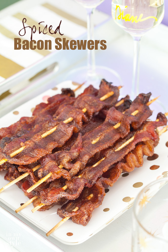 Spiced Bacon Skewers on party plate and a glass of champagne.