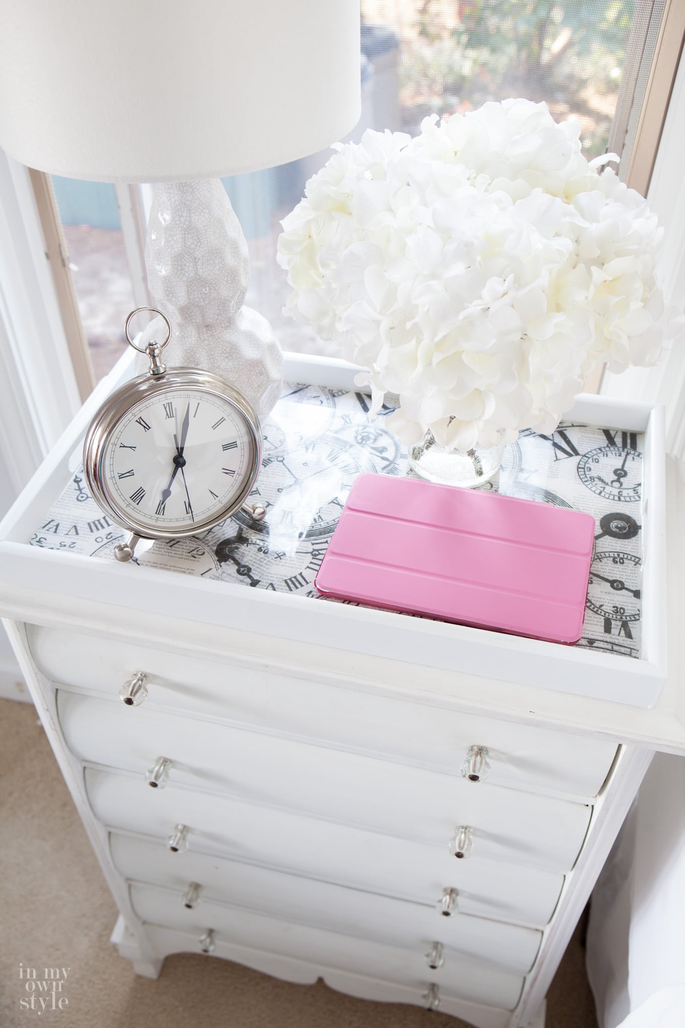 Night table with second hand thrift store tray on top that was made over using paint and scrapbook paper.