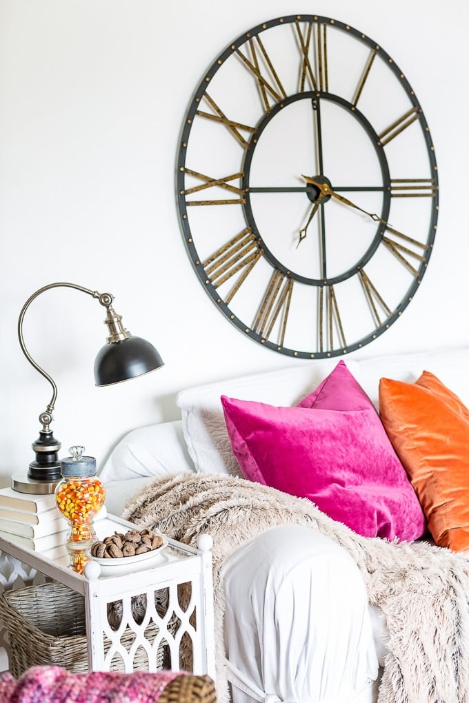 Modern decorating for fall in white living room with pops of fall colors.