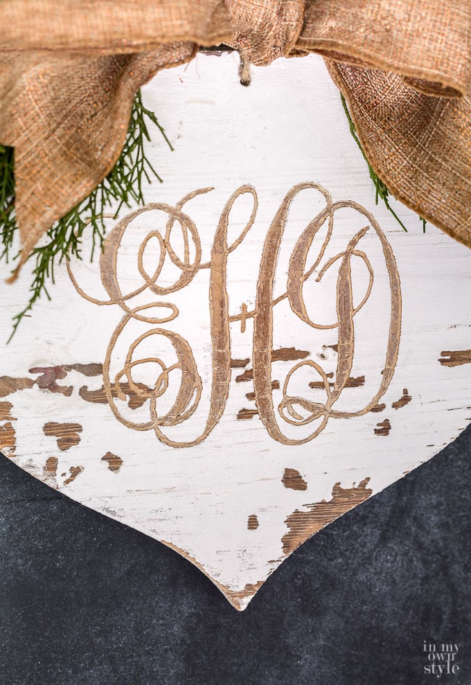 Monogram carved into a wood Christmas ornament