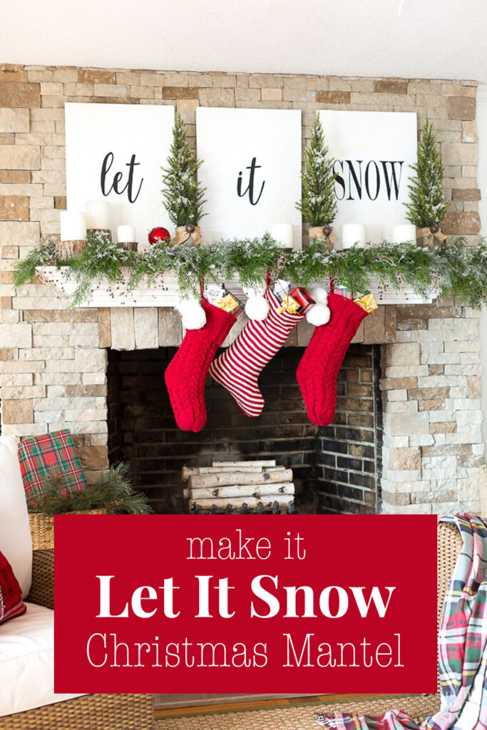 A white mantel on a stone fireplace decorated with white signs that say Let it Snow