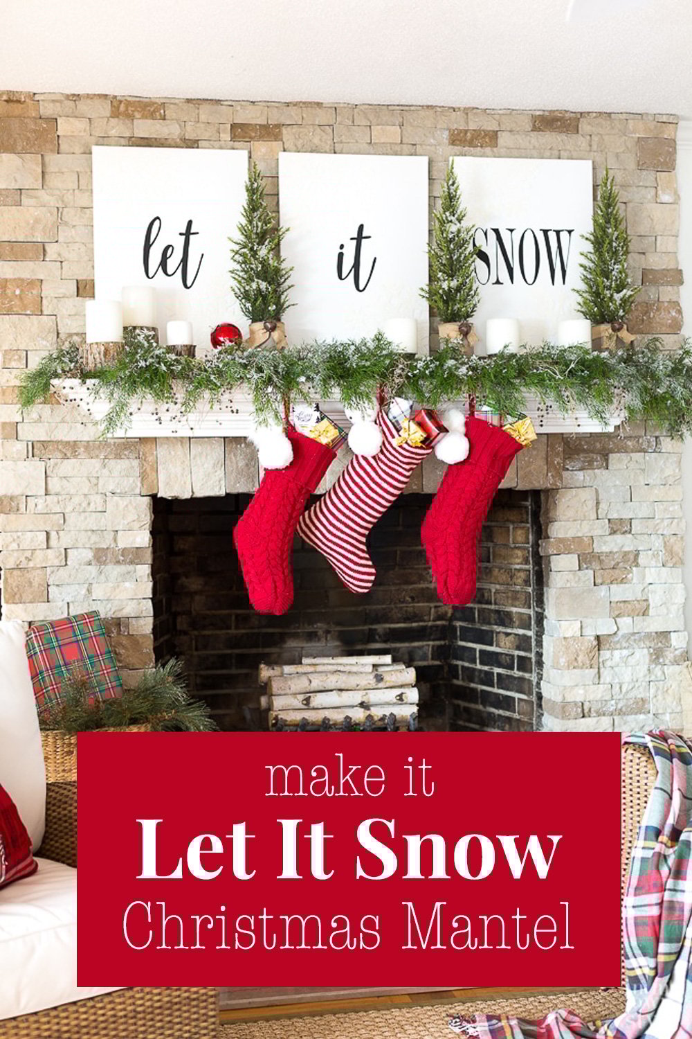 A white mantel on a stone fireplace decorated with white signs that say Let it Snow