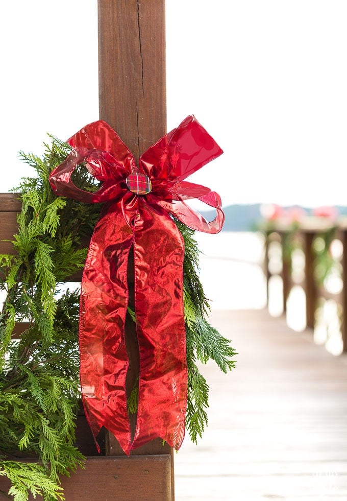 Outdoor Christmas decorating idea using cedar roping and red ribbon