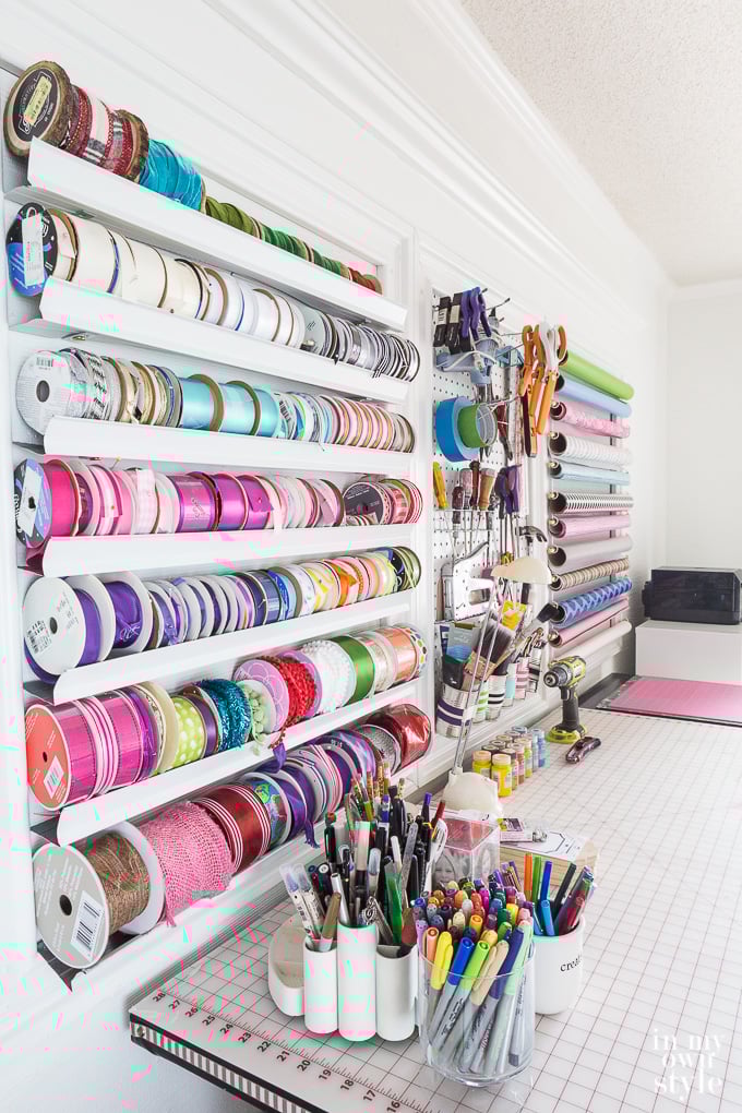 Craft room with wall organizers and a long worktable.