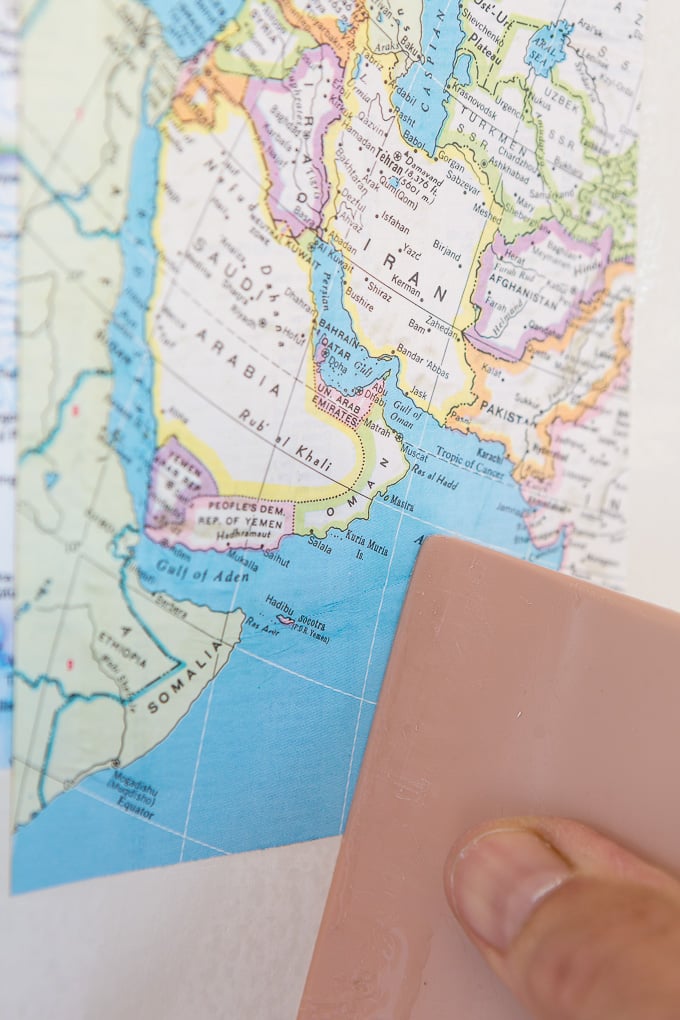 DIY map wallpaper step by step tutorial that shows how to remove wrinkles that may appear when applying maps and or paper to walls