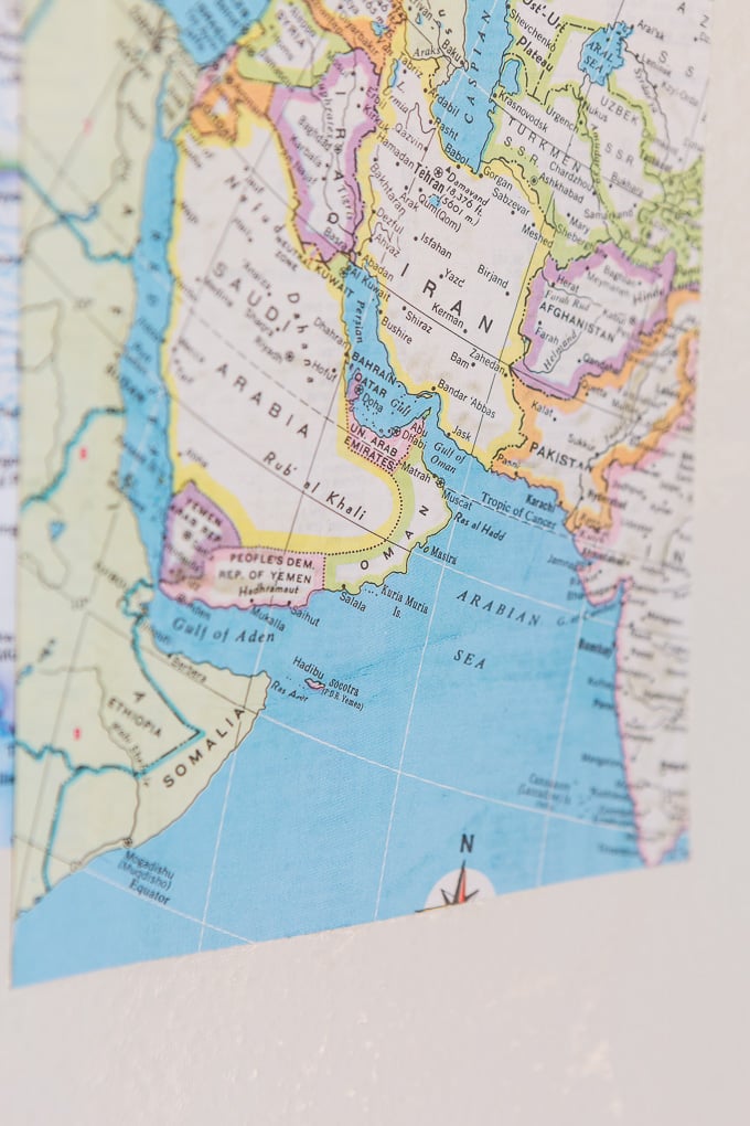 DIY map wallpaper step by step tutorial that shows how to remove wrinkles that may appear when applying maps and or paper to walls