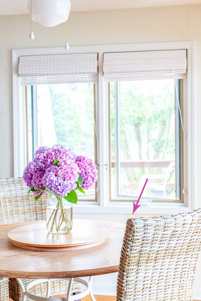 Hydrangeas on kitchen table agains white textured wallpaper