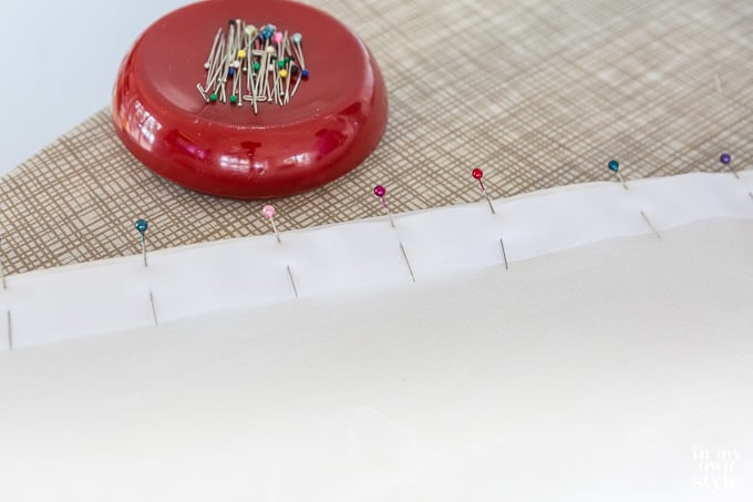 DIY step by step tutorial showing how to make an Ottoman Slipcover with Removable Large Pom Pom Trim