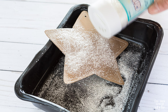 Sprinkling glitter on one star ornament.