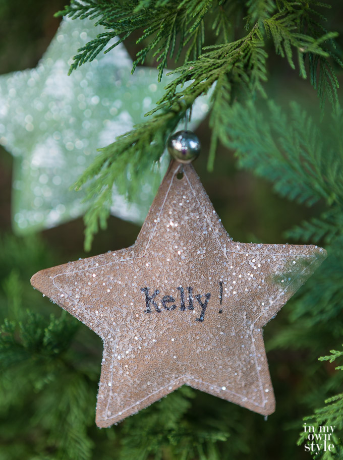 Brown paper star ornament that is glittered and had the name Kelly on it.
