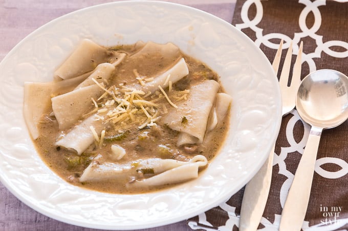 A bowl of leftover stew on a table.