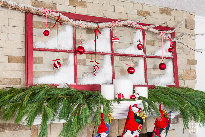 Muntin glass and wood window sash painted red and used as Christmas decor on a fireplace mantel.