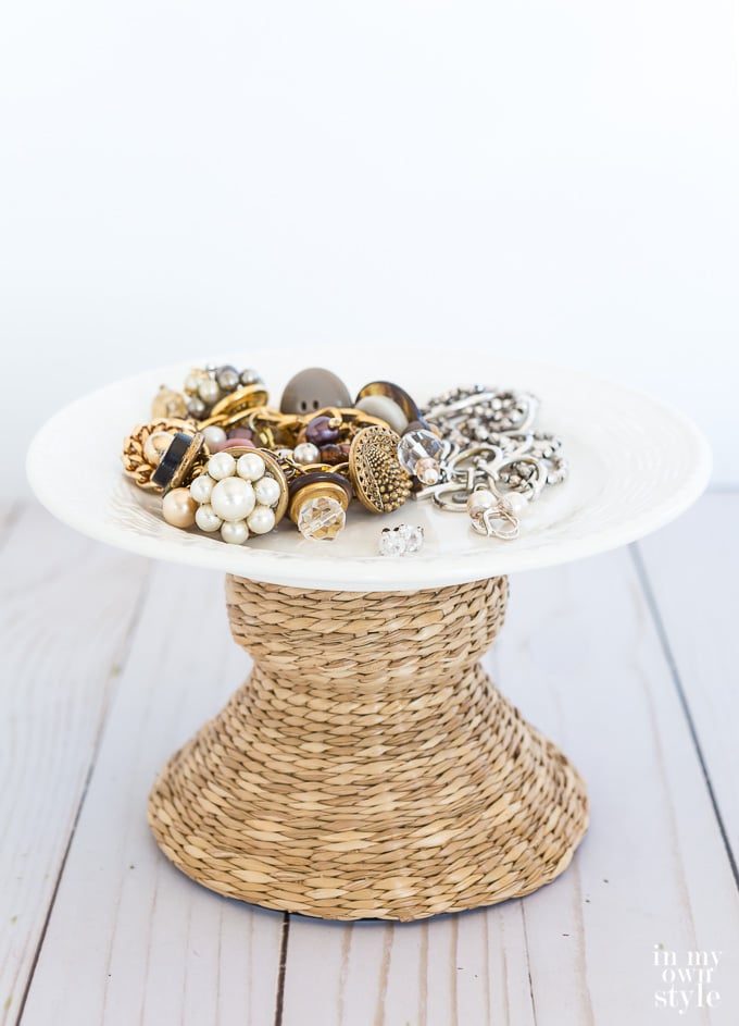 Jewelry on a plate on top of a wicker candle holder