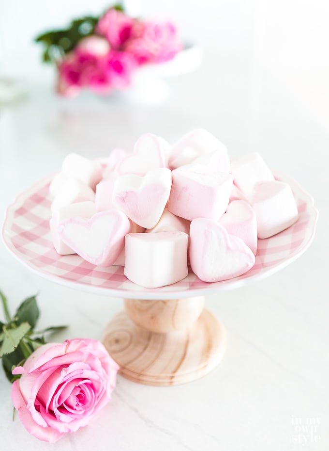 heart marshmallows on top of a pink and white checked plate
