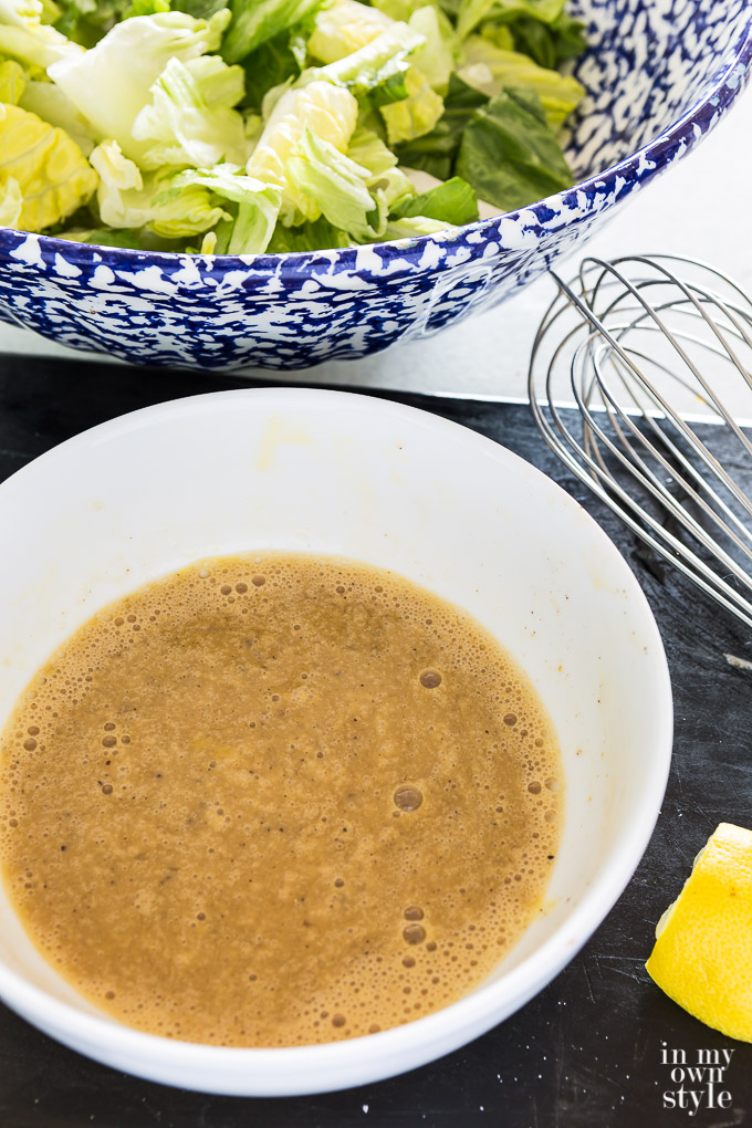 Bowl of Cesar salad ingredients just whisked to combine them.