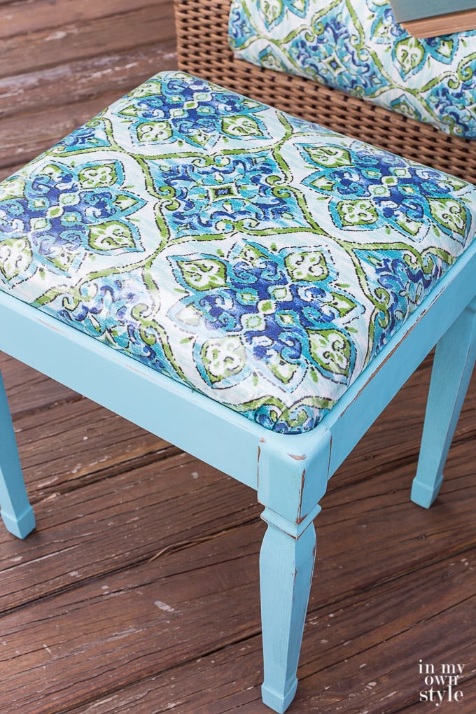 Close up of the top of the newly painted turquoise and fabric covered stool.