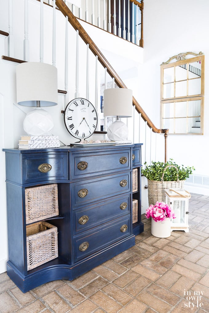 Navy Blue chalk painted chest of drawers in foyer with brick floor